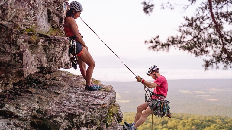 Man and woman rock climbing