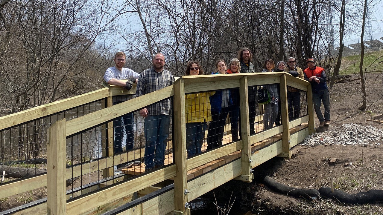 Volunteers standing on a trail bridge