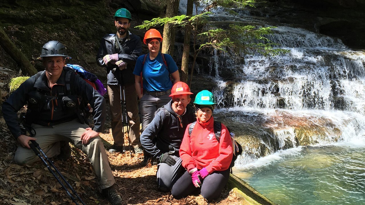 Volunteers with hard hats on at a waterfall