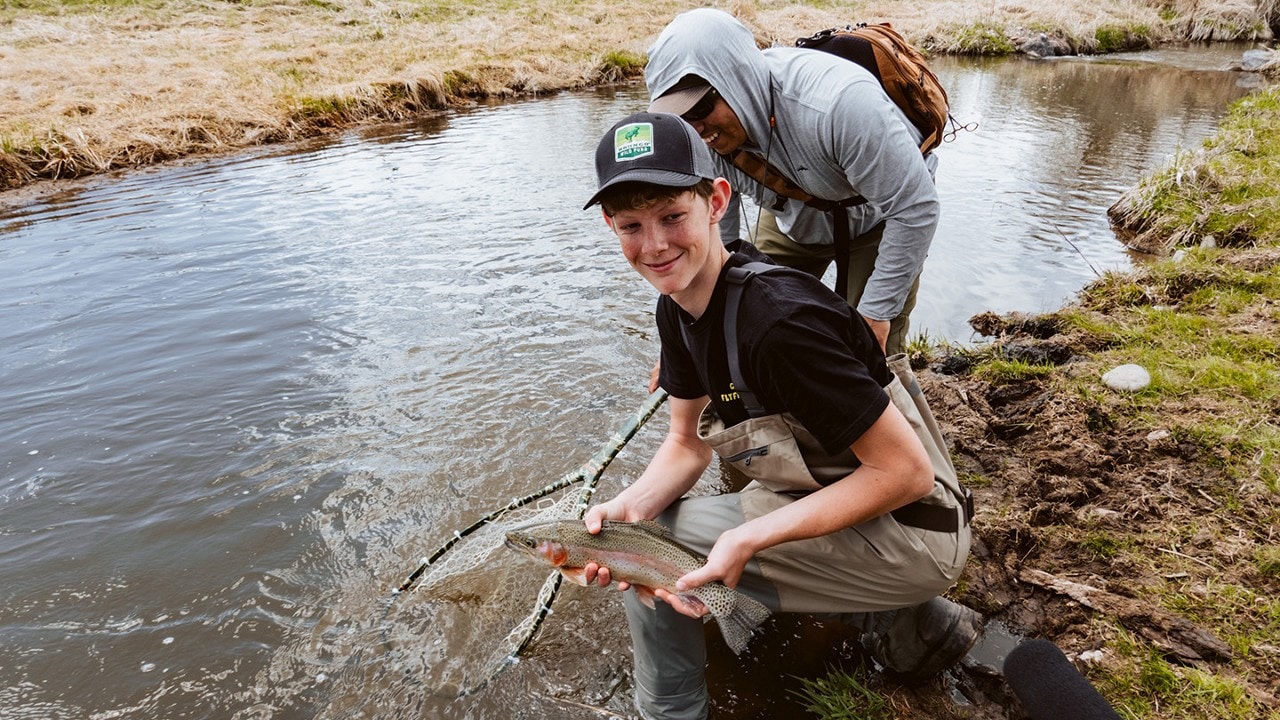 Two grant volunteers at a riverbed catching fish