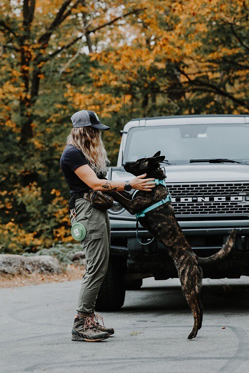  A woman and dog hugging in front of a Bronco® SUV.