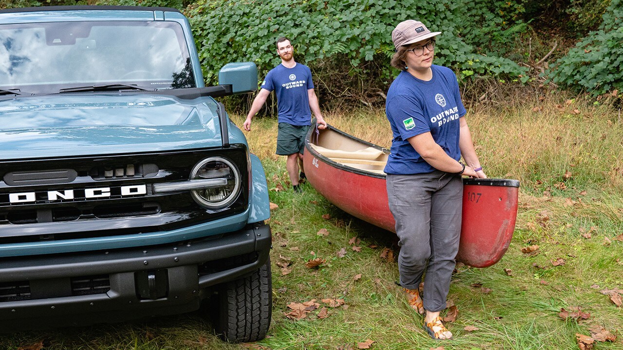 Outward Bound students carrying a canoe.