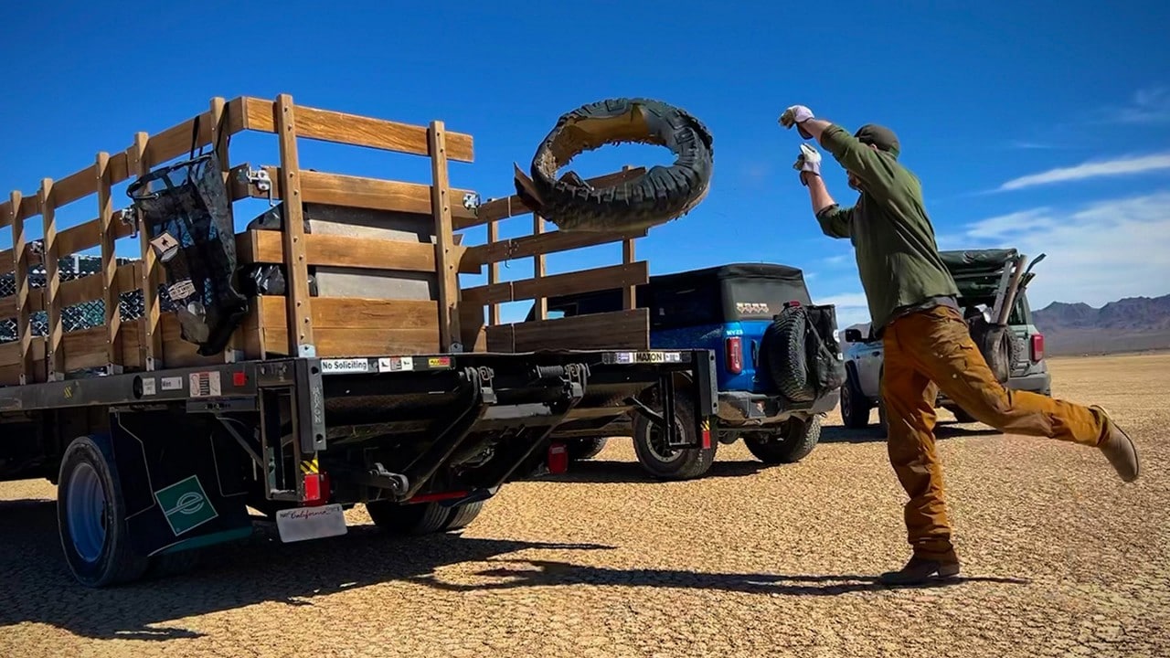 Volunteer throwing rubber from a tire into the back of a truck