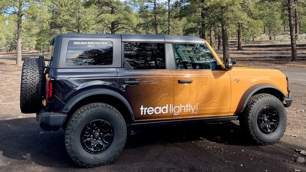 Bronco® SUV with a Tread Lightly! wrap parked on a dirt road