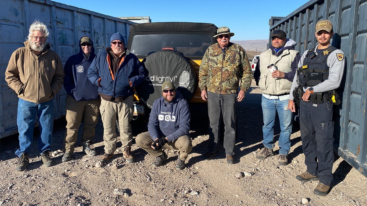 Tread Lightly! volunteers and law enforcement officer lined up before a Bronco® SUV