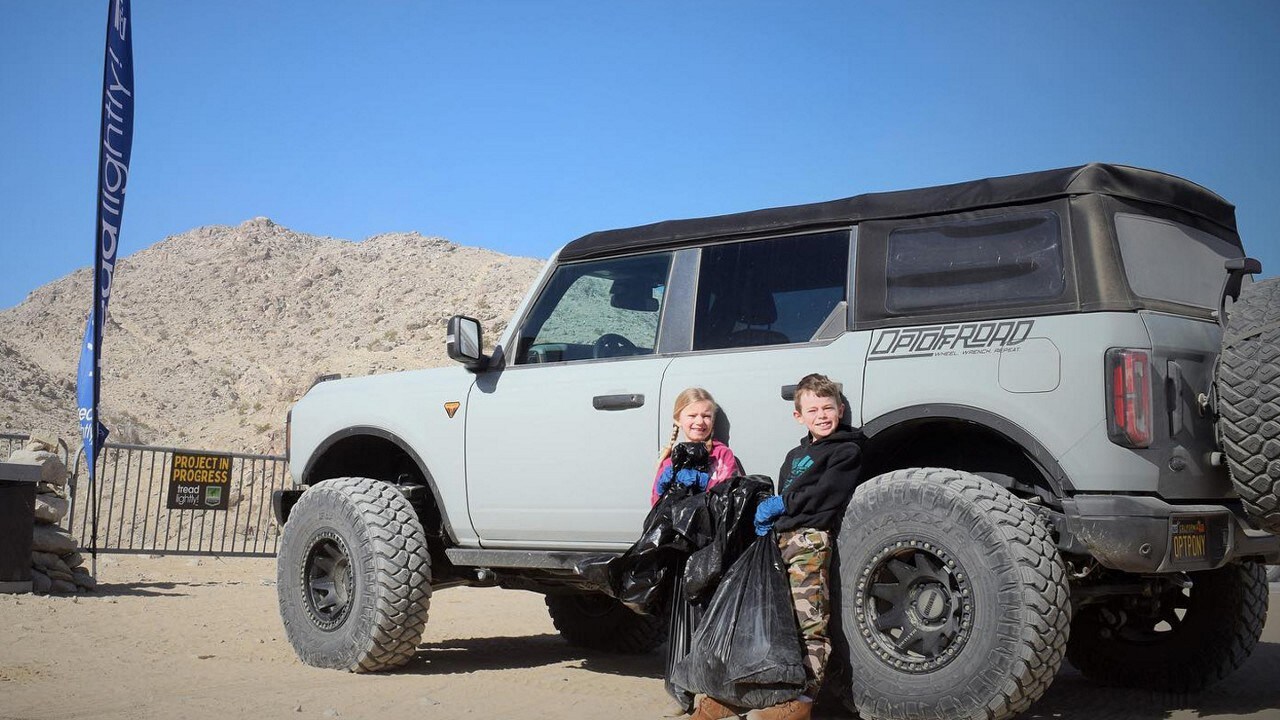Two volunteer children standing beside a Bronco® SUV