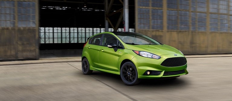 Ford Fiesta in Mean Green Metallic parked in front of a warehouse