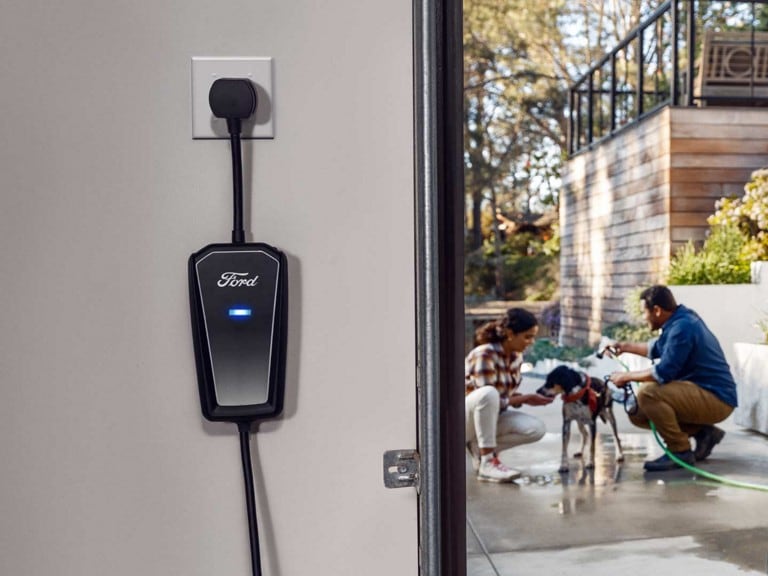 A Ford Mobile Power Cord plugged into the power outlet of a residential garage