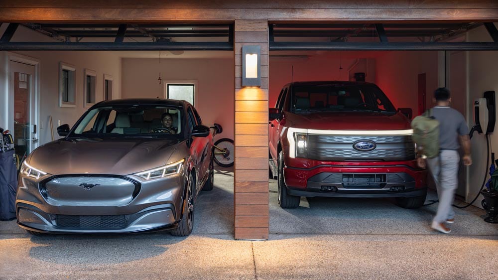 A Mustang Mach-E® and F-150 Lightning® parked side by side in a residential garage