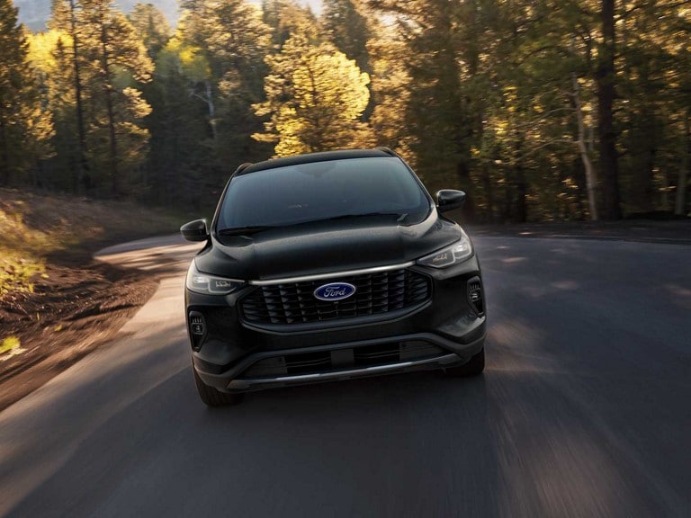 An Escape® Plug-In Hybrid SUV being driven on a wooded road