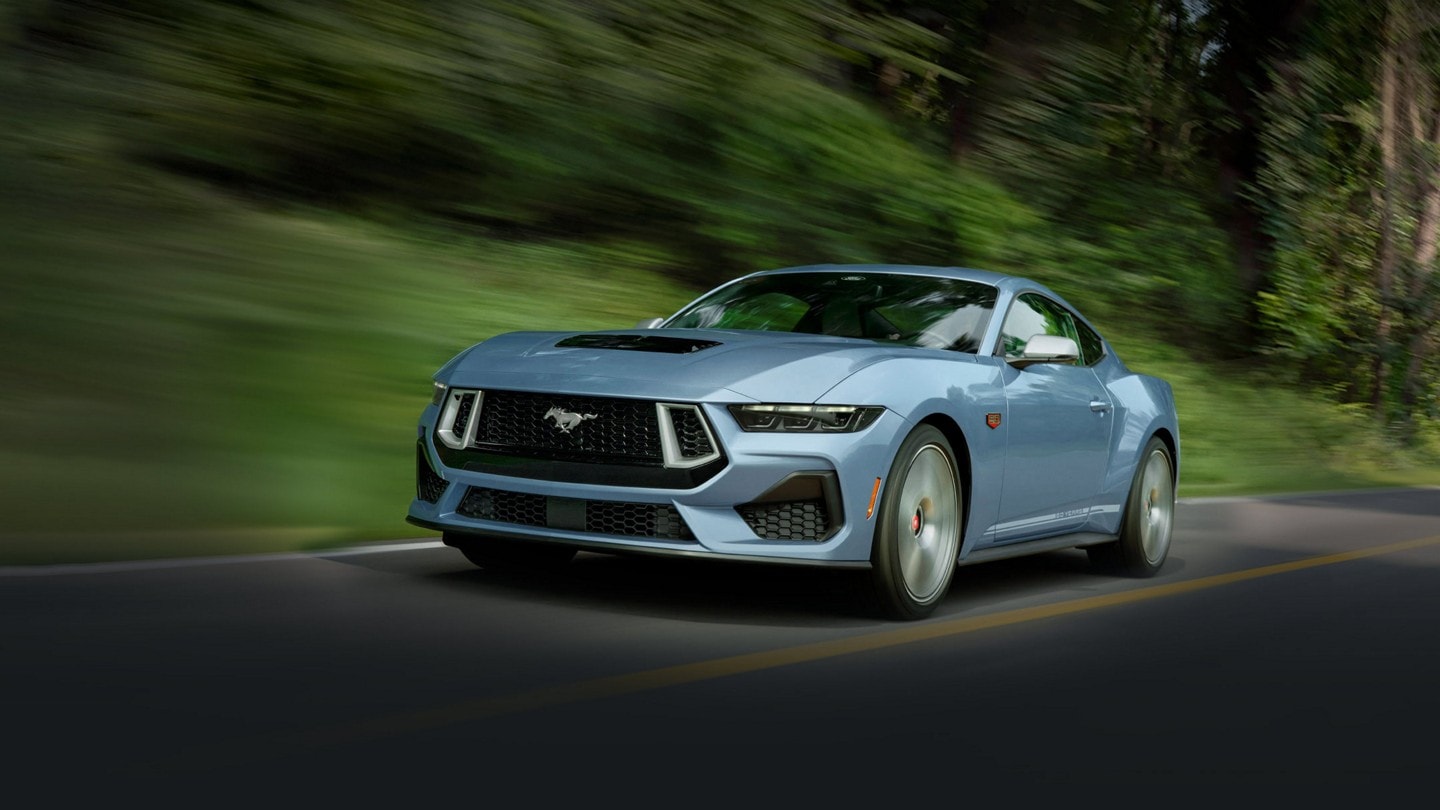 2025 60th Anniversary Ford Mustang® GT coupe in Brittany Blue being driven on a road