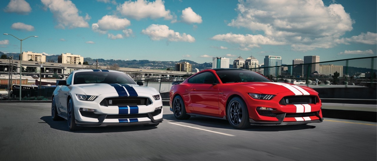 A pair of Shelby G T three fifties parked side by side in a rooftop lot