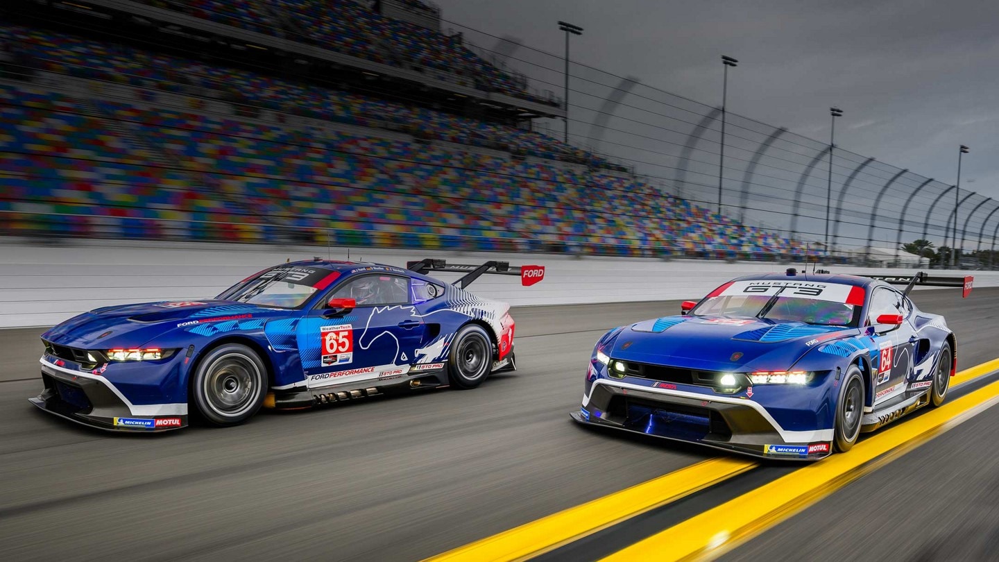 Two Ford Mustang® GT3 race cars driving side by side on an enclosed racetrack