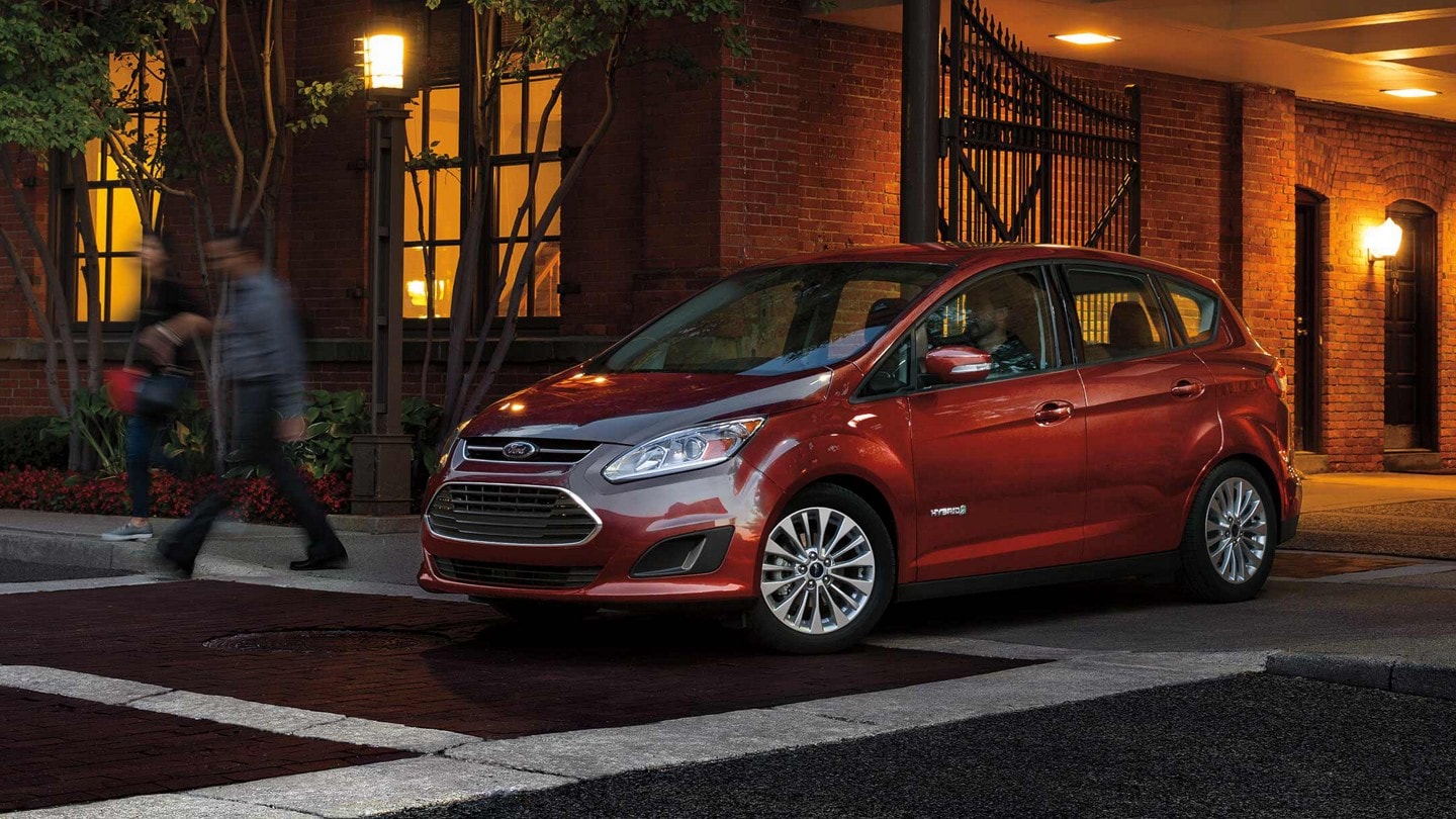 2023 Ford C-Max Hybrid SE in Ruby Red Metallic Tinted Clearcoat being driven in the city at night