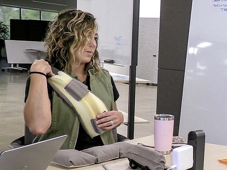 A woman tries on a prototype of the Ford SupportBelt seat belt accessory.