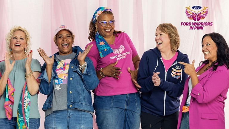 Group photo of female breast cancer survivors wearing Warriors in Pink merchandise in support of the breast cancer cause.