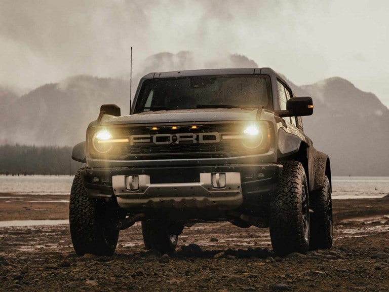 A grey Ford Bronco Raptor® being driven across a rocky terrain.