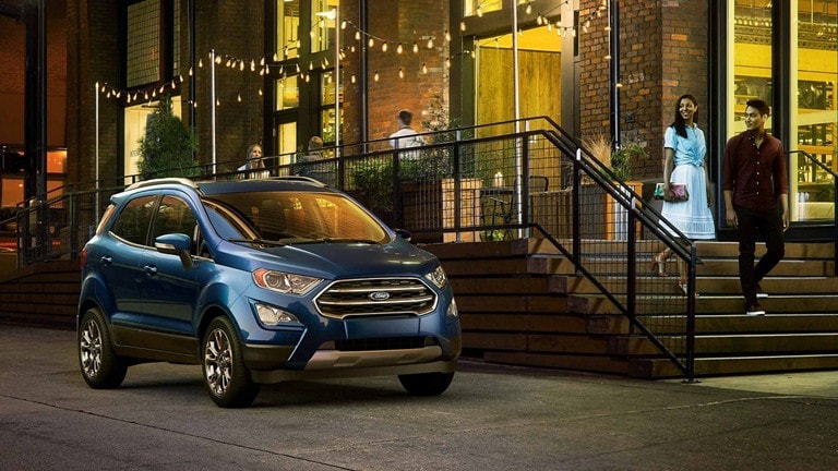 A couple walks toward a 2022 Ford EcoSport® at night