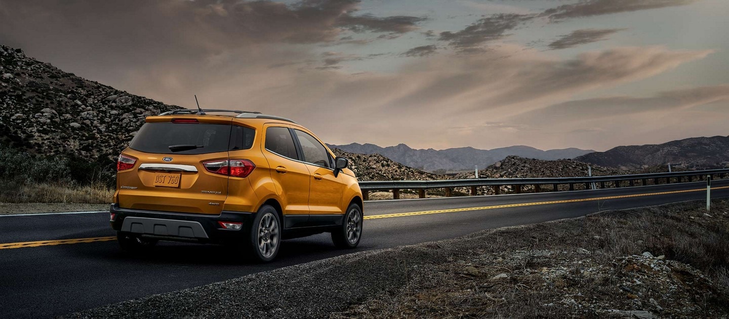 2022 Ford EcoSport(r) in Luxe Yellow Metallic being driven on mountain road below dark clouds
