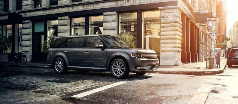 Ford Flex Limited being driven near a stone building in the city