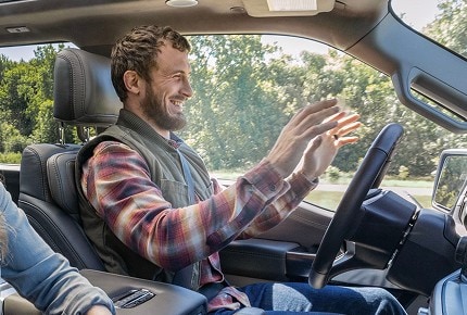 Still image from a video showing a man behind the wheel of a vehicle with his hands off the wheel