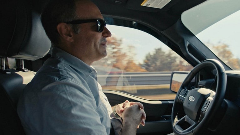 Interior of Mustang® Mach E®, driver sits with hands off steering wheel
