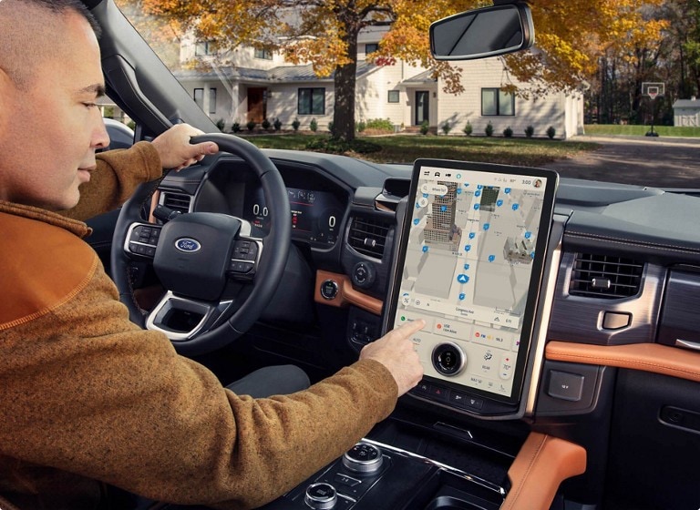 A driver searching for a destination on the Ford Connected Navigation screen while parked.