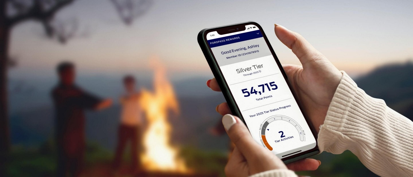 Close-up of an owner’s hands holding a mobile device displaying the available FordPass® Rewards Points information.