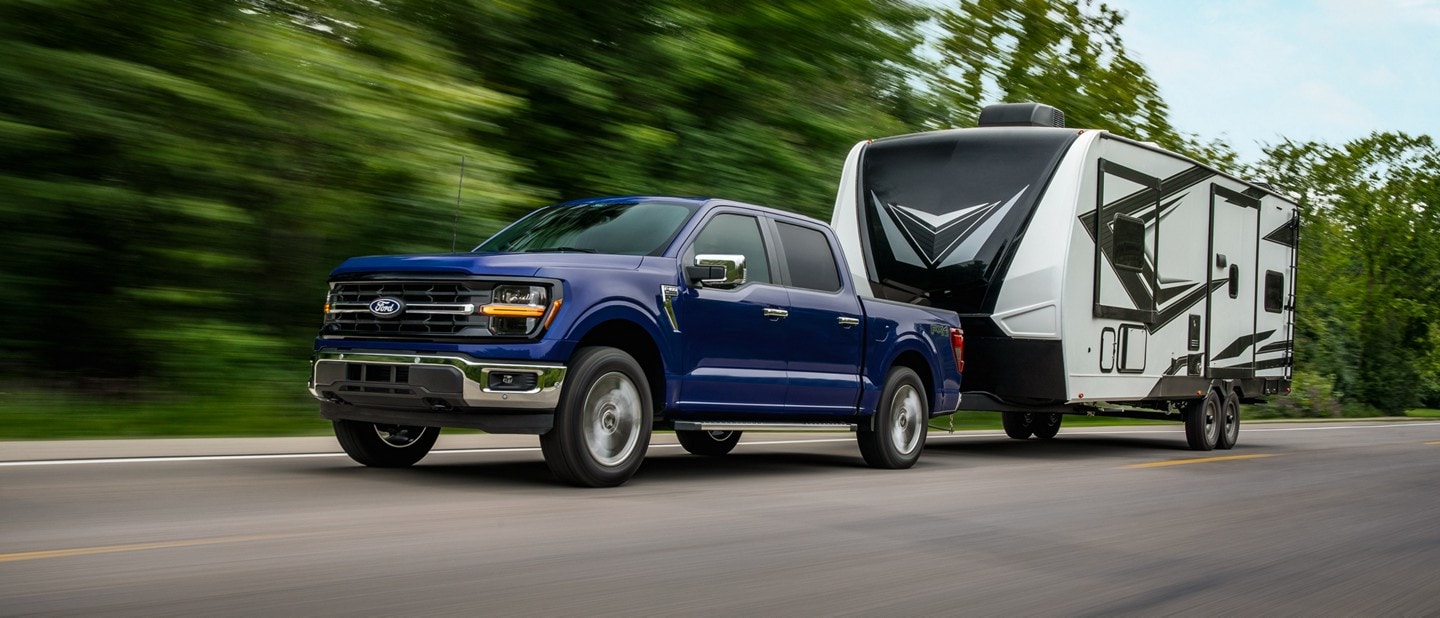 2026 Ford F-150® XL pickup in Argon Blue Metallic pulling a camper