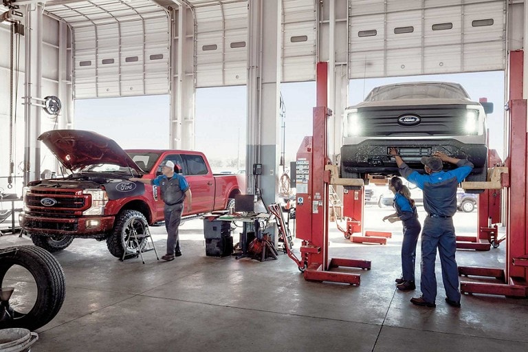 Two vehicles being worked on at an auto shop