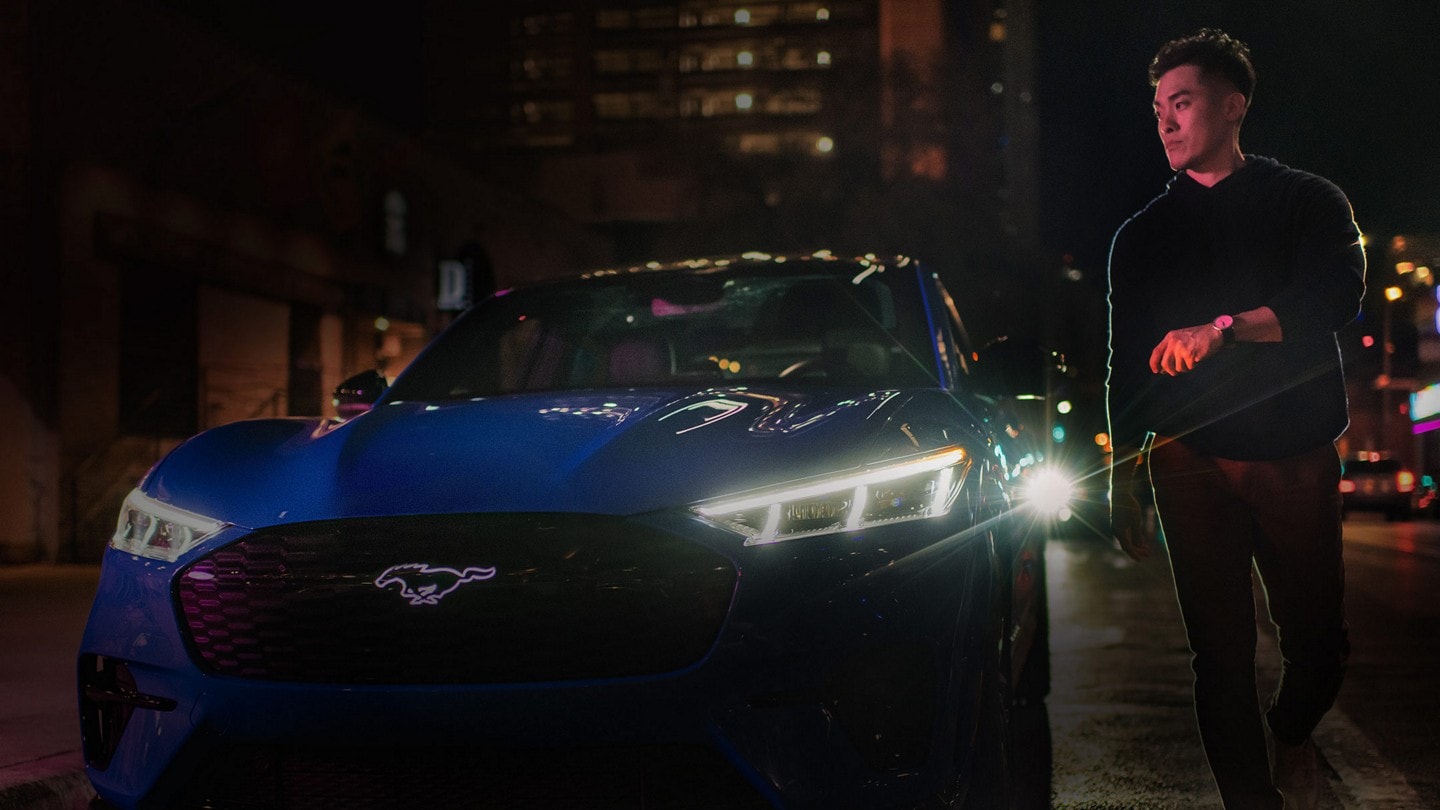 A man pointing his key fob at his Mustang Mach-E GT Performance Edition.