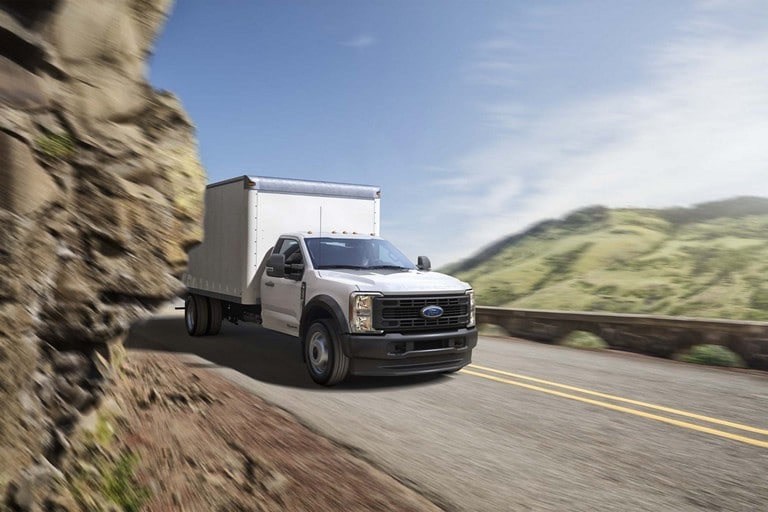 2025 Ford Super Duty® F-450 XL with a box being driven through a tight mountain curve