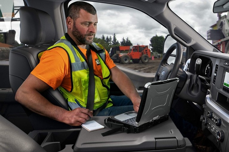 Person using a laptop computer inside a 2025 Ford Super Duty® XL pickup