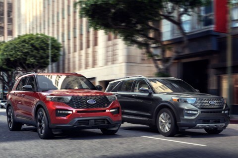 Two 2020 Ford Explorer models being driven on city street alongside one another