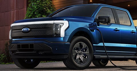 Una Ford® F-150 Lightning 2022 cargándose en una carretera de noche