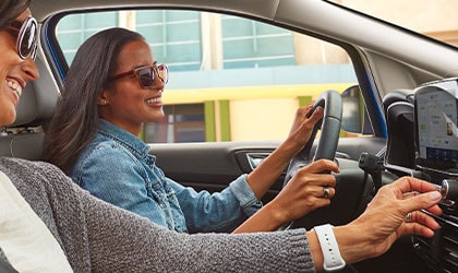 Side view of female driver and female passenger in 2020 Ford EcoSport under open sunroof