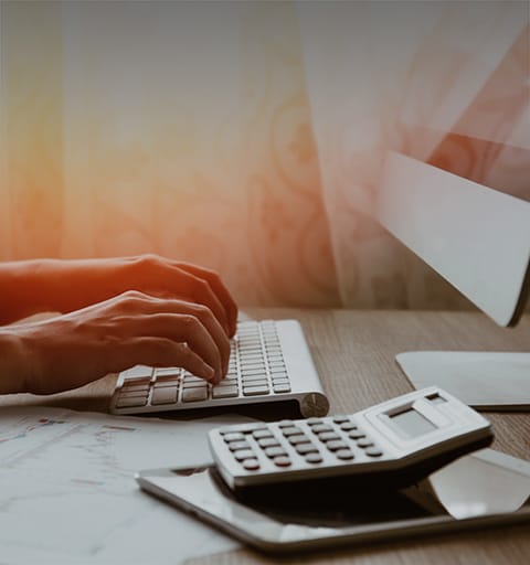 person's lower arms typing on the computer