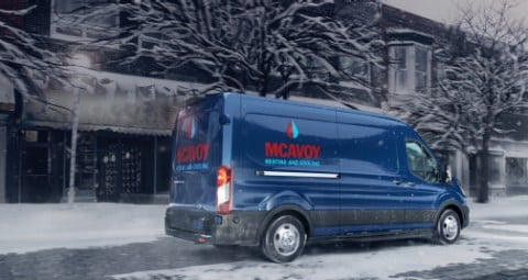 2020 Ford Transit Cargo Van in Blue Jeans with custom branding being driven on snowy street during storm