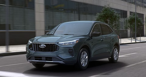  2024 Ford Escape in Vapor Blue Metallic being driven down a city street