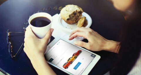 Person at desk with coffee cup and computer tablet