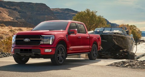 Ford F-150® truck pulling boat on a trailer at boat launch.