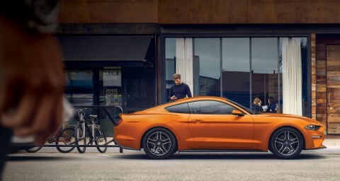 Ford yellow Mustang infront of building