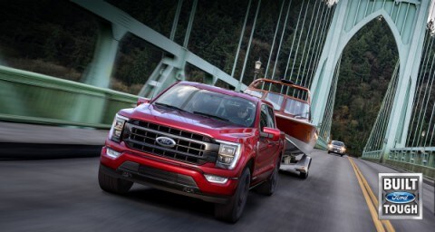 A 2021 Ford F One Fifty towing a boat over a bridge