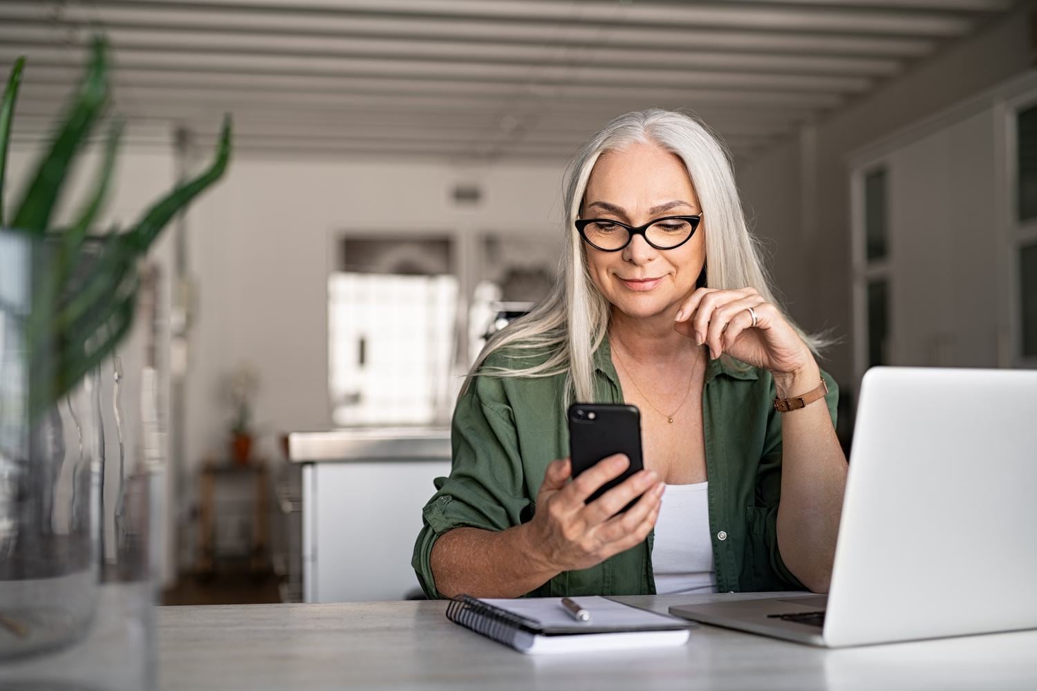 A woman sitting at a table looking at her phone