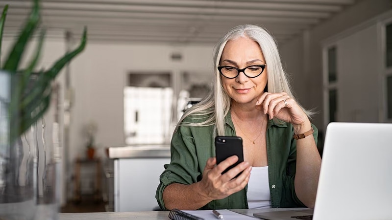 A woman in her home looking at her phone