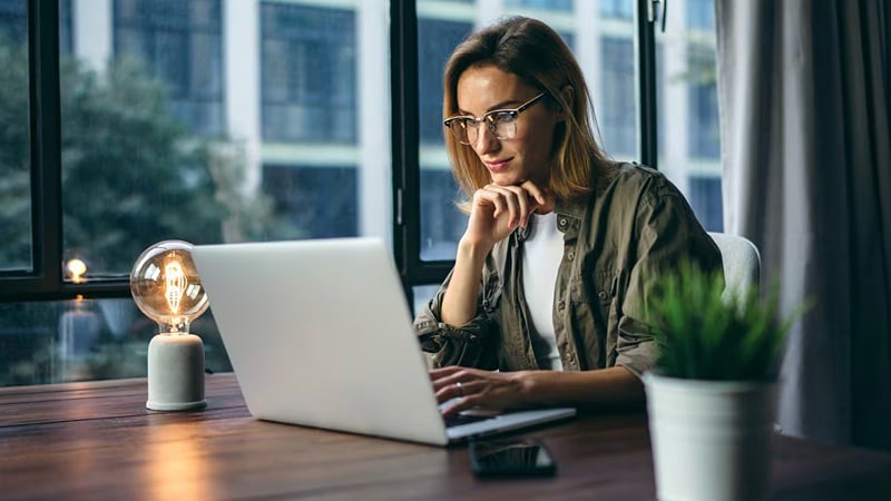 A woman in an office looking at her laptop