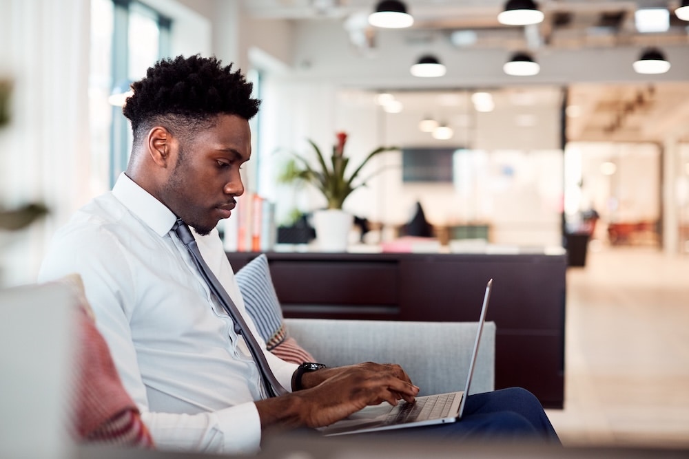 Young professional working on a laptop in a modern office.
