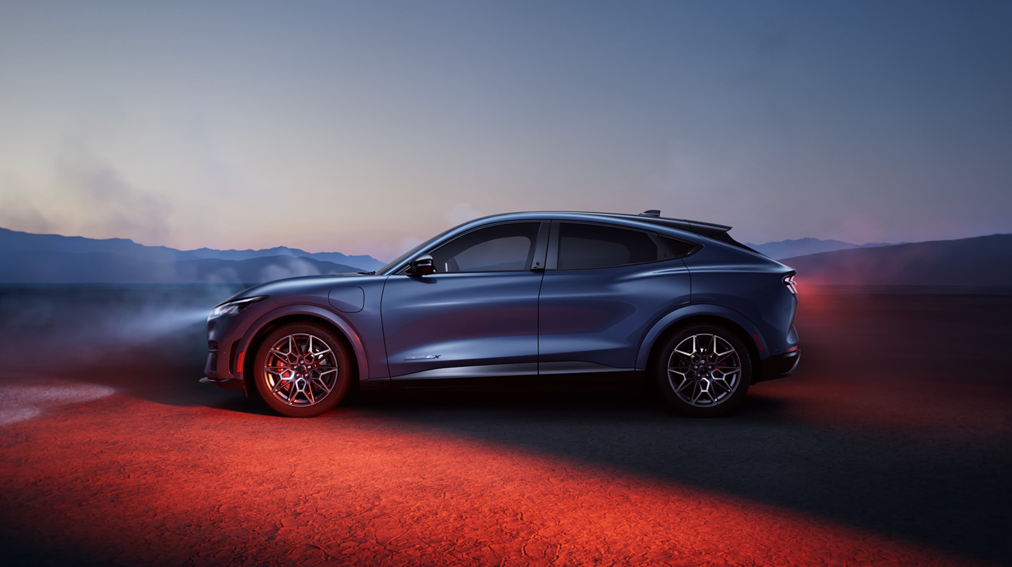 Le côté d’une Ford Mustang Mach-E stationnée au coucher du soleil.