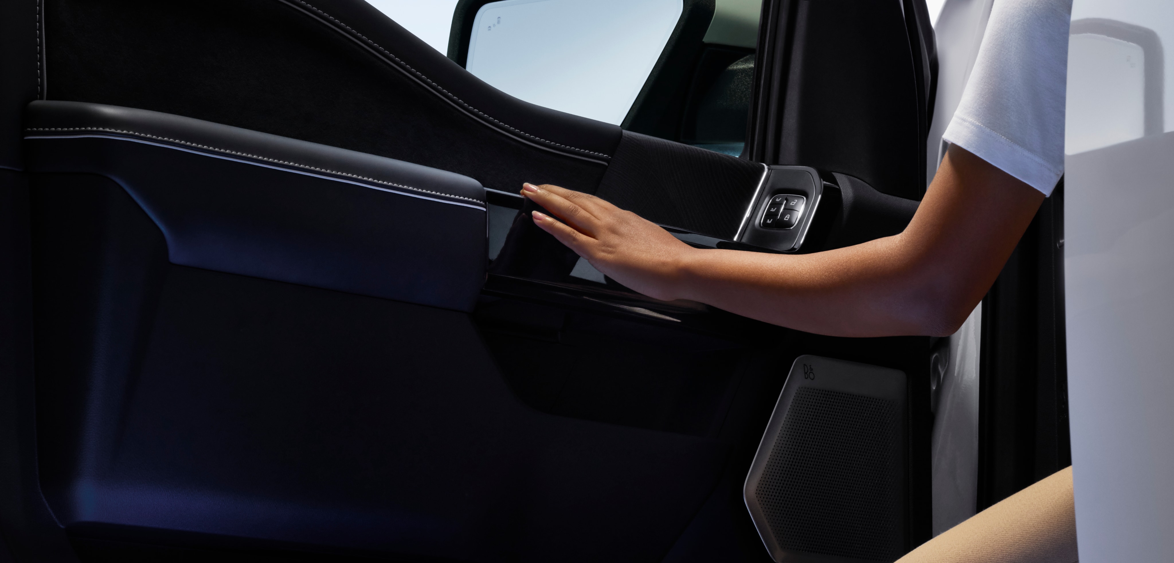 Woman’s left arm reaching out of Ford vehicle to grab the open door handle