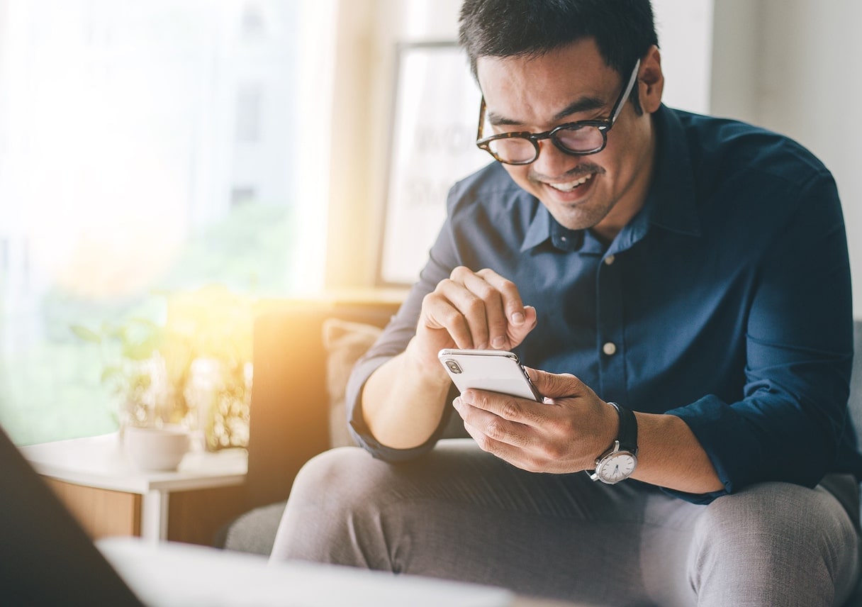 Smiling person in glasses signs up for e-statements on a smartphone.